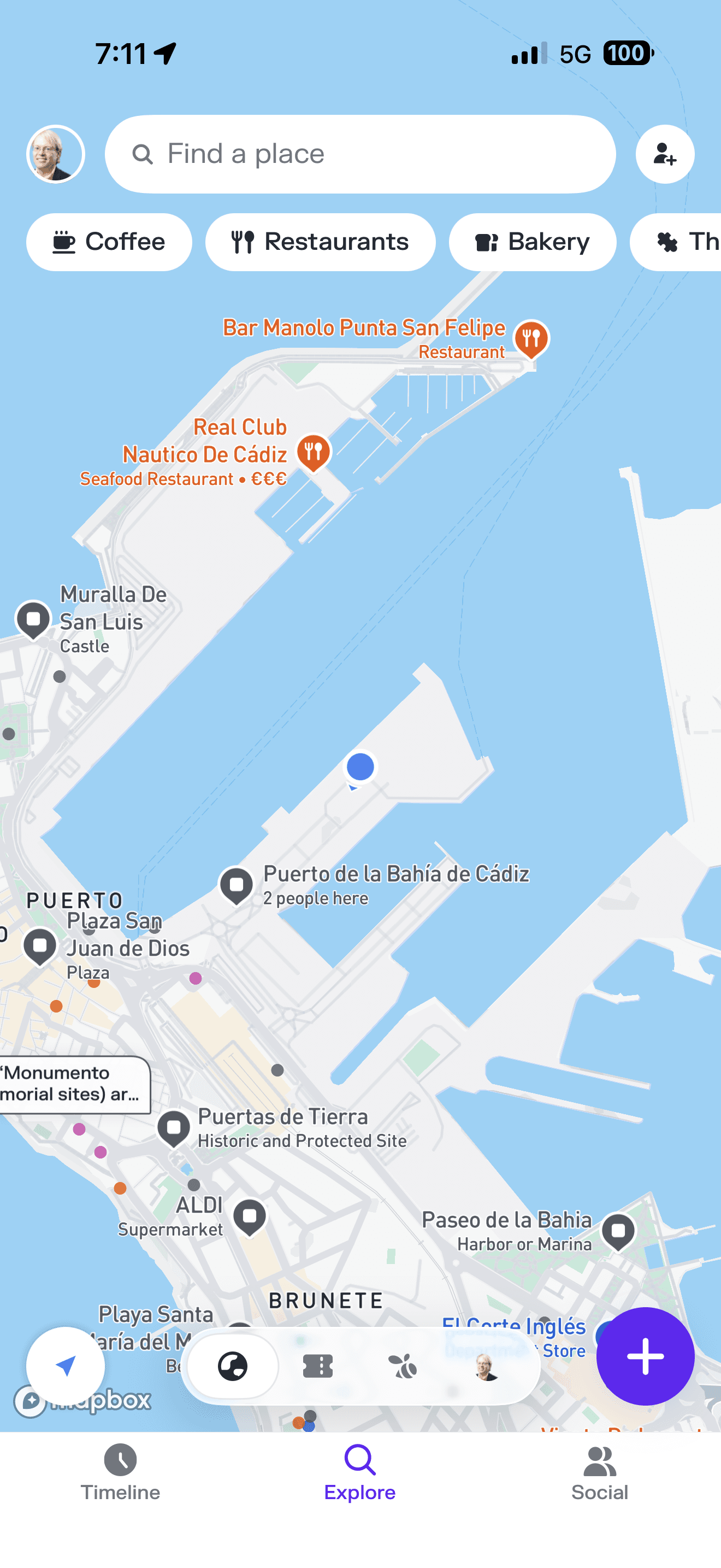 Mobile map app showing Cádiz, Spain harbor area with pins for Puerto de la Bahía, historic sites, and seafood restaurants alo